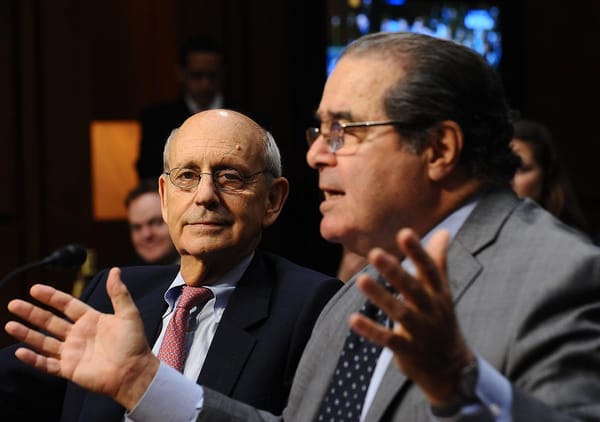 Scalia speaking gestures with hands Breyer stares into camera with bemusement possibly boredom or fatig