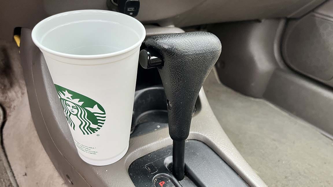 Cup out of cupholder resting against gear selector