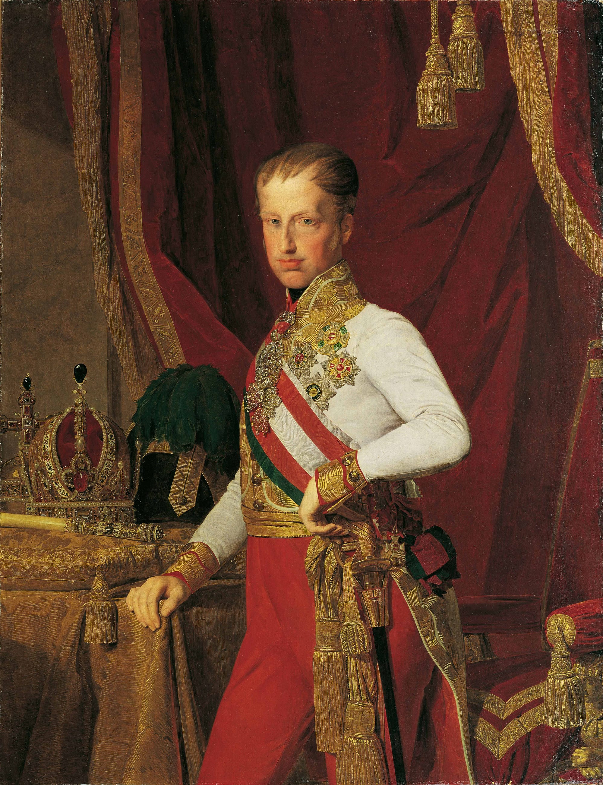 Ferdinand resplendent in red trousers, a waistcoat full of medals, and a golden sash.