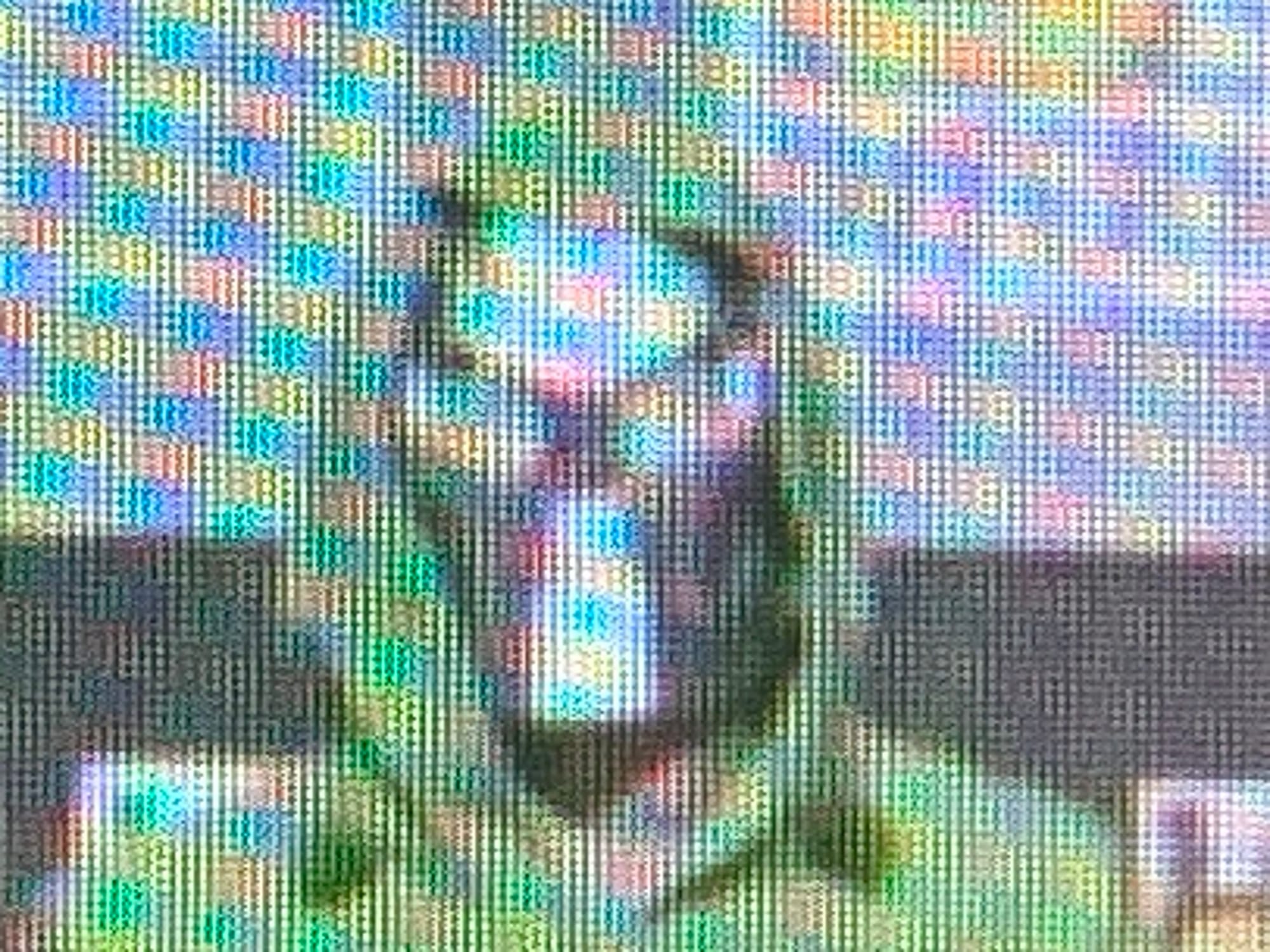 A bleary, pixel-heavy close-up photograph of a computer screen showing the head and shoulders of a figure in a green caped hood with a shiny mask on its face that looks at least as much like Kylo Ren's mask as it does Victor von Doom's. 