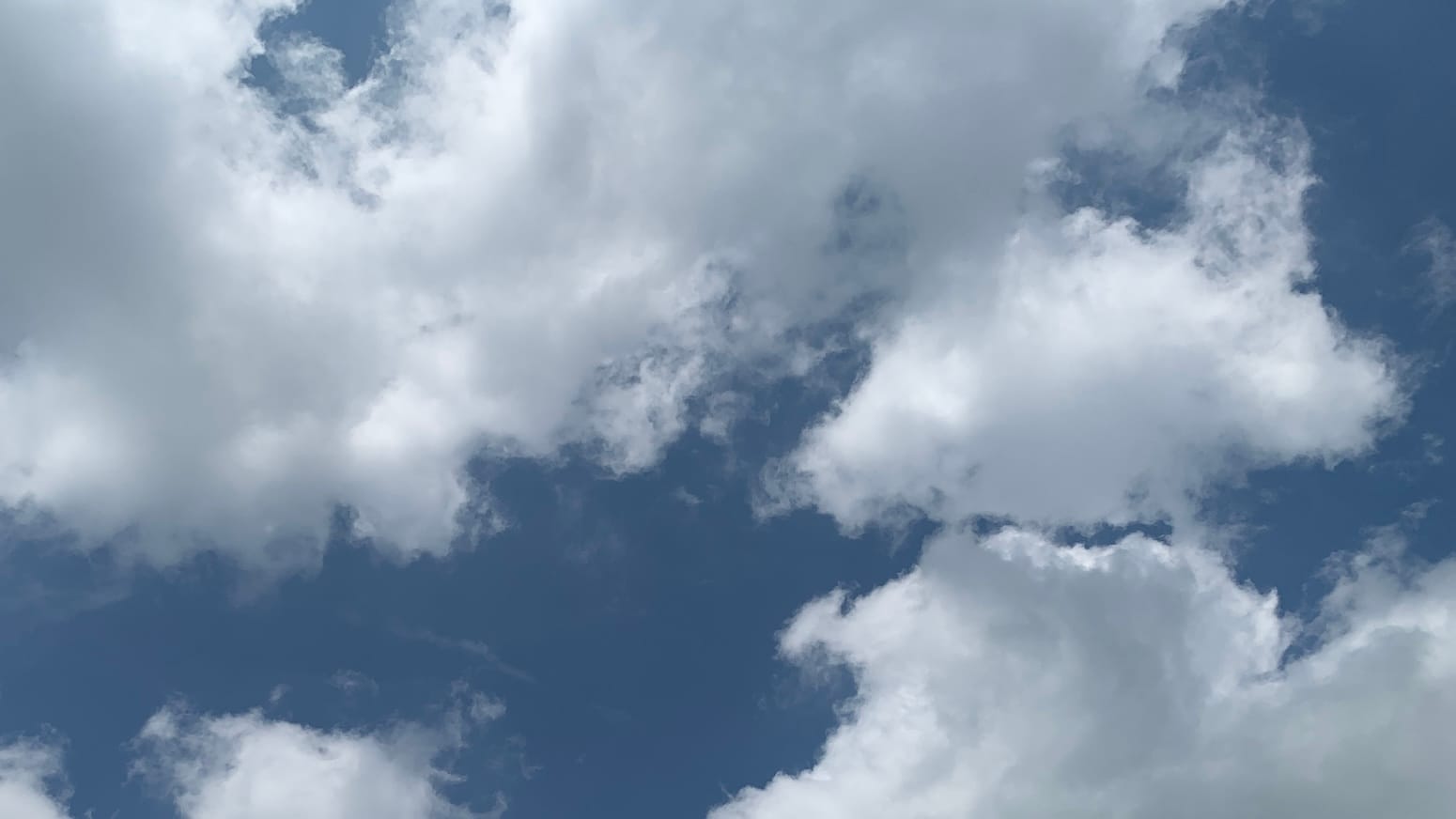 Blue sky and fluffy clouds interlocking like puzzle pieces