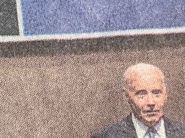 Detail of NYT photo of Biden presser showing Biden and a fragment of the NATO OTAN backdrop