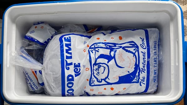 A 7 lb. bag of GOOD TIME ICE featuring a cartoon of a polar bear chillin' and the slogan THE NATURAL COOL in a Coleman cooler