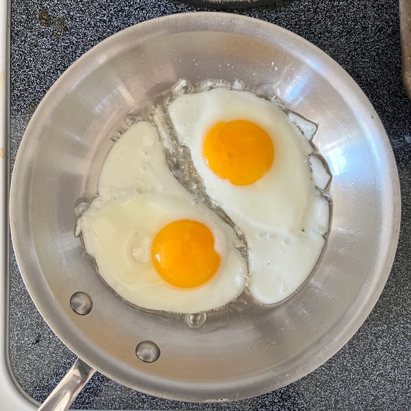 Some eggs frying in a pan