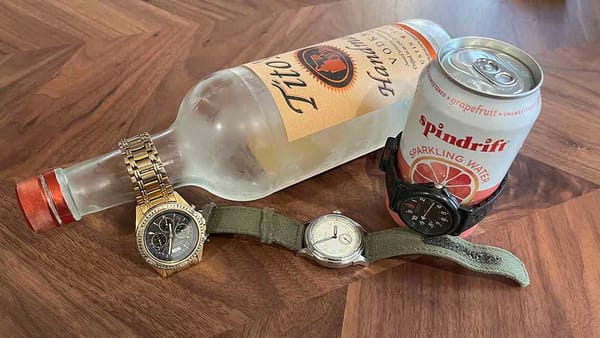 A right-outta-the-freezer bottle of TITO'S, a can of SPINDRIFT sparkling water, and some wristwatches